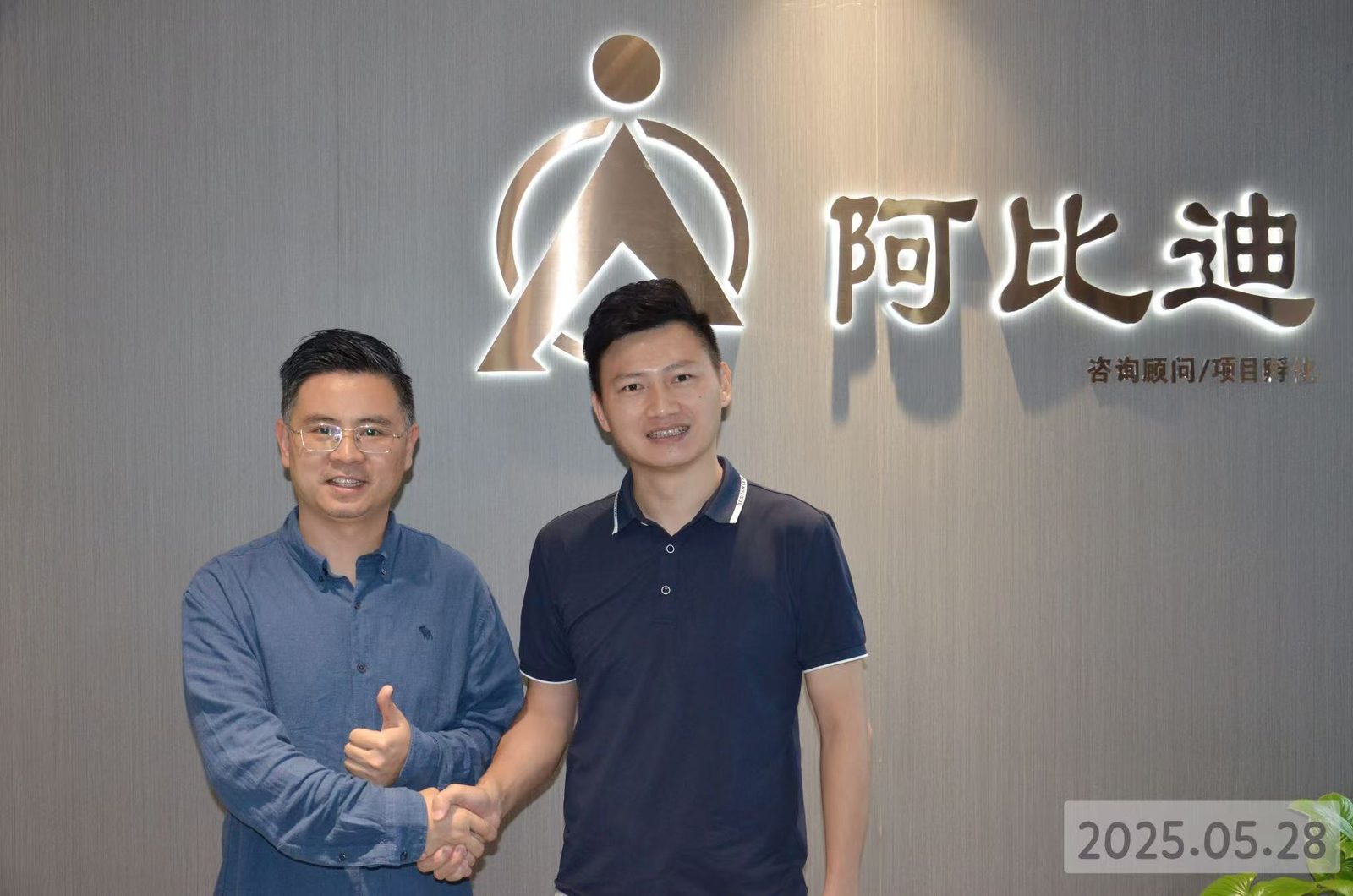 阿比迪团队成员在阿比迪品牌墙前合影